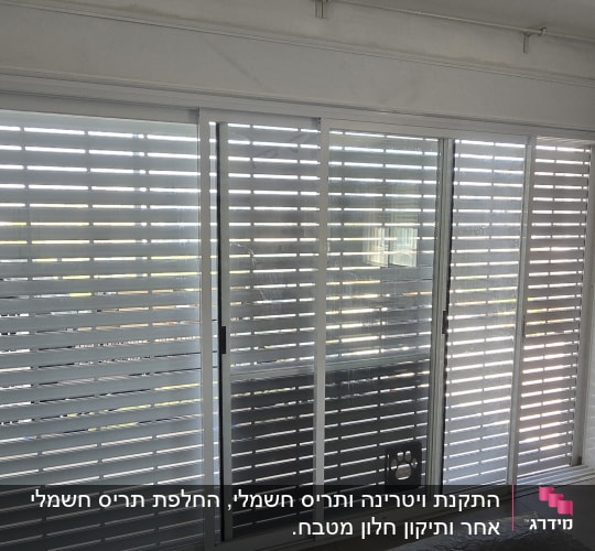 תריסי אלומיניום בחלון גדול בחדר פנימי